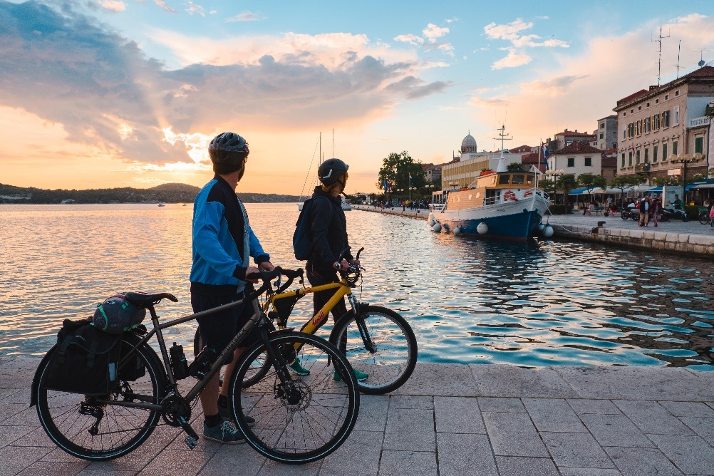 Two people standing next to each other with bicyclesAI-generated content may be incorrect.