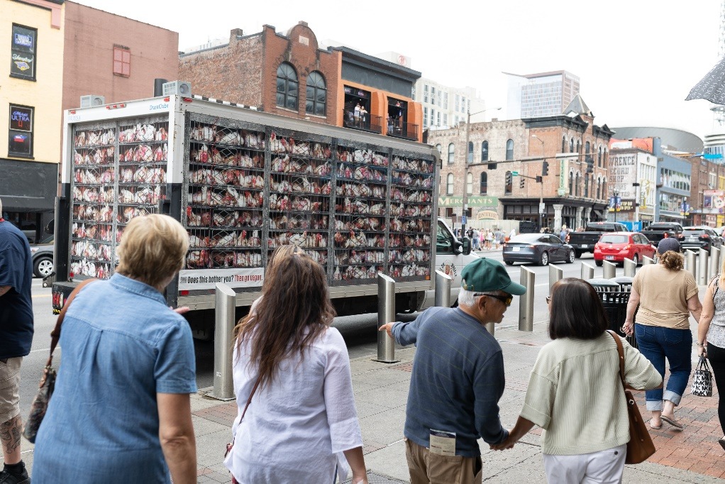 A group of people standing in front of a truckDescription automatically generated